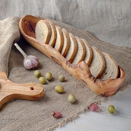 Olive wood bread basket with sliced bread showing natural grain and shape