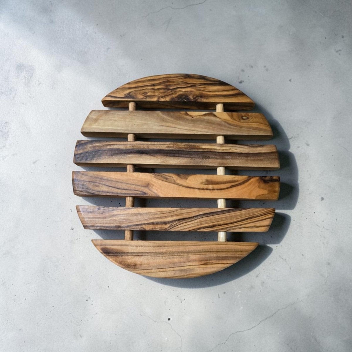 OLIVIKO handcrafted round olive wood trivet close-up – natural grain patterns, solid Mediterranean olive wood